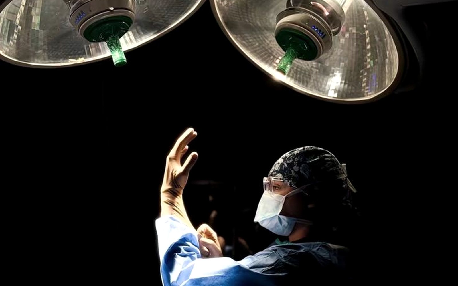 A surgeon working under bright theatre lights